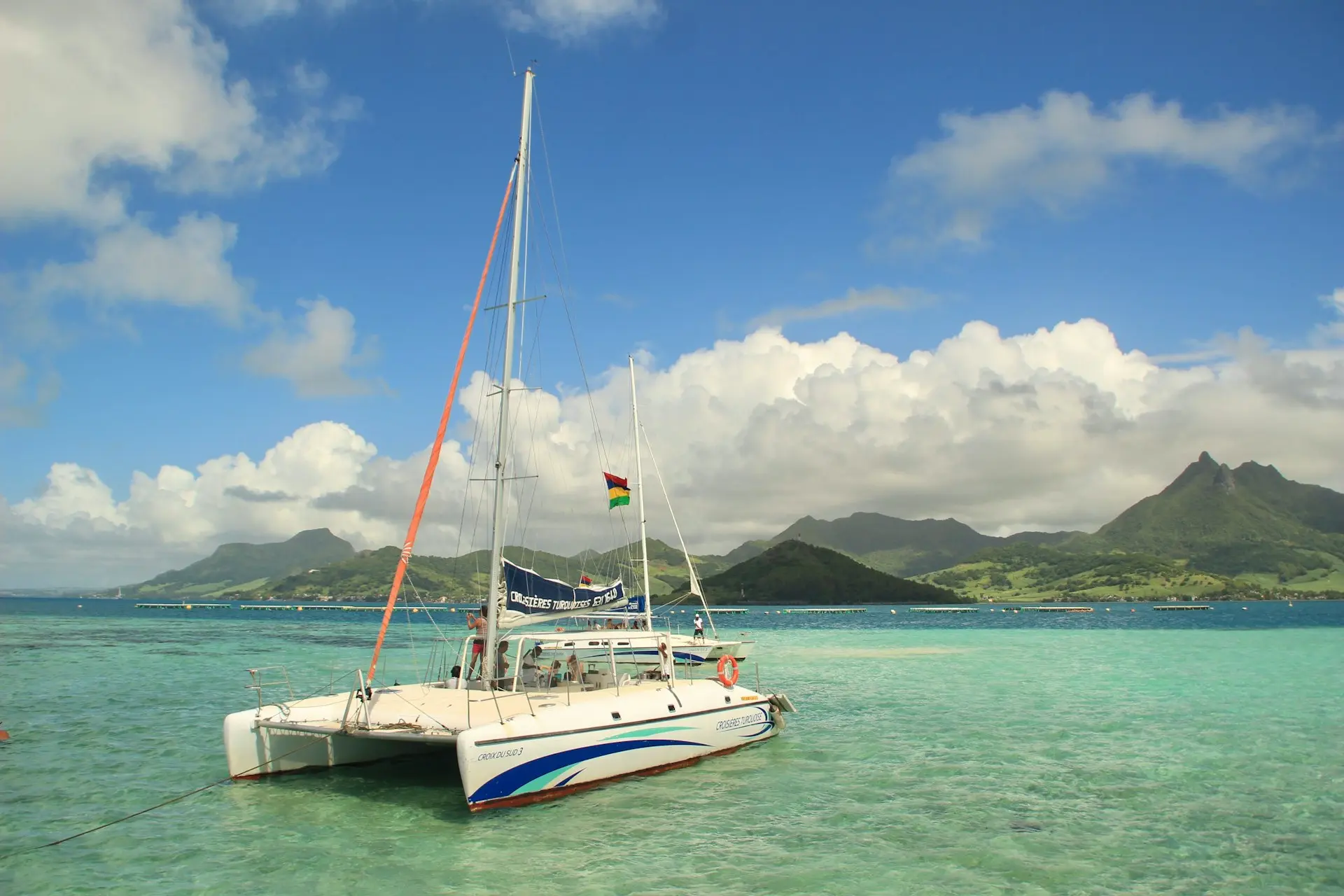 a sailboat in the water with mountains in the background