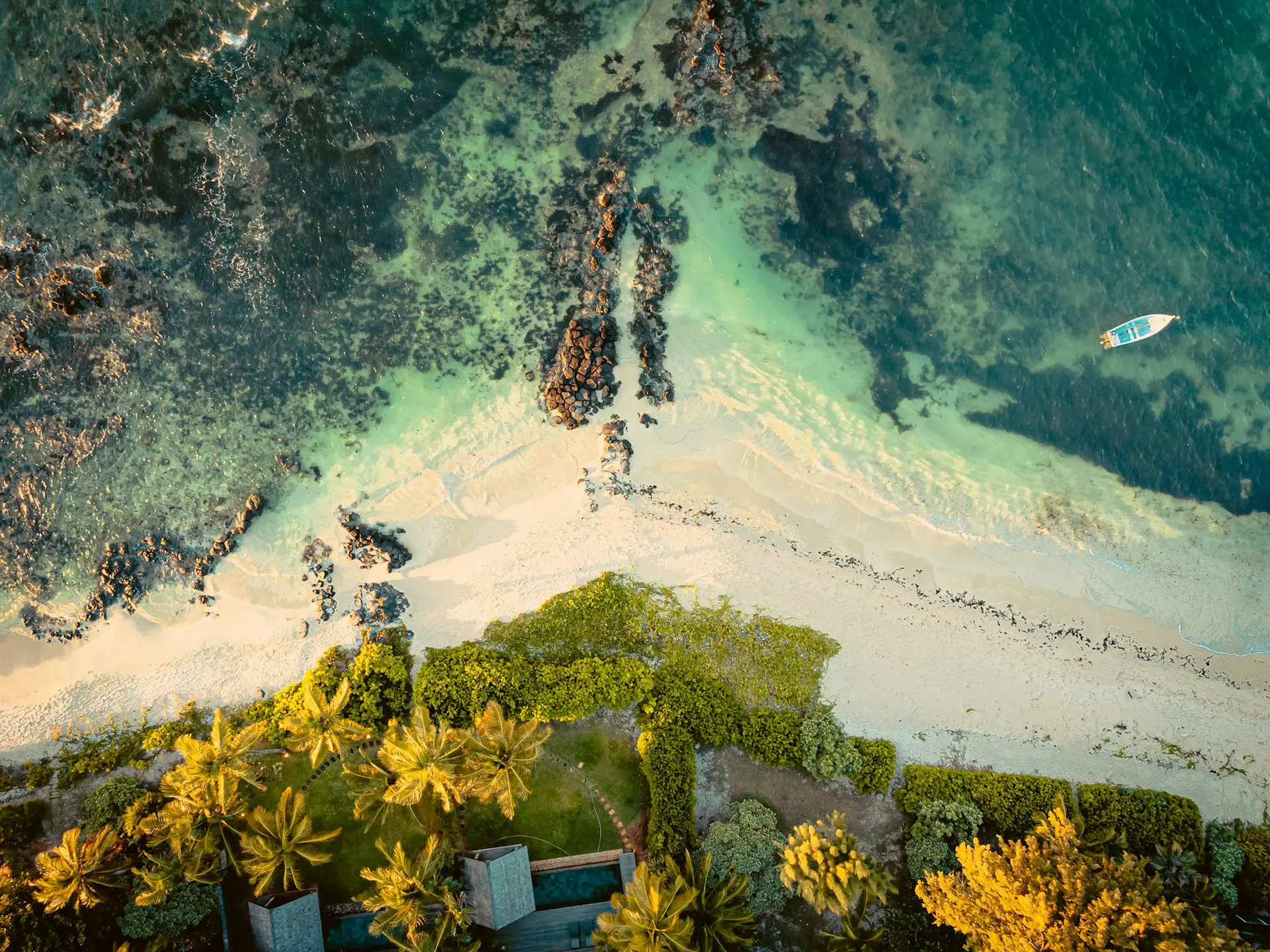 an aerial view of a beach with a surfboard in the water